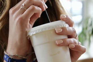 person holding white plastic cup
