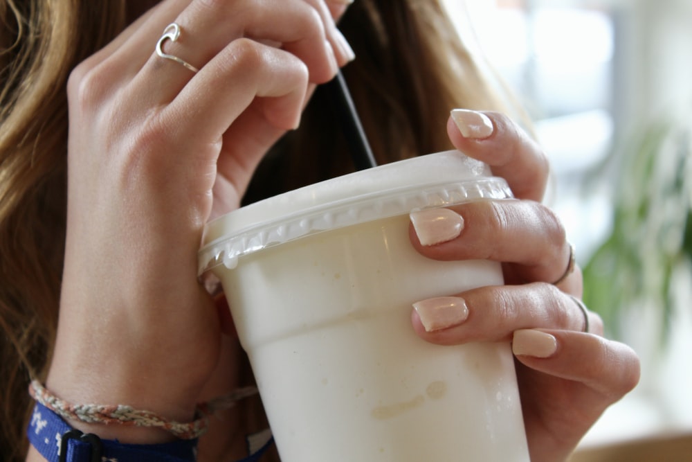 person holding white plastic cup