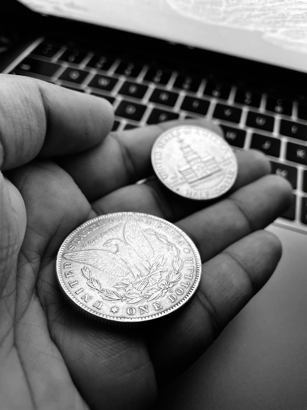 Persona sosteniendo una moneda redonda de plata