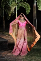 woman in purple and brown sari standing on brown wooden bridge