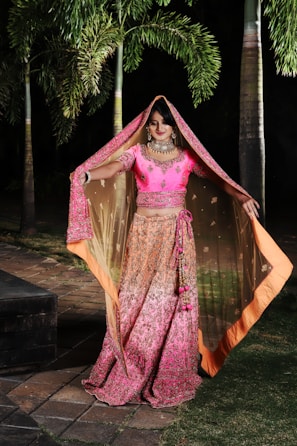 woman in purple and brown sari standing on brown wooden bridge