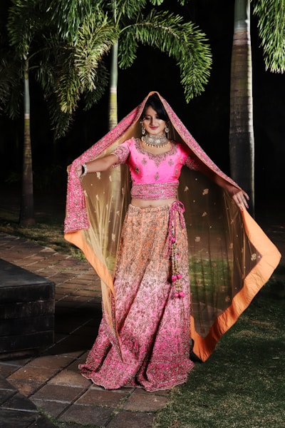 woman in purple and brown sari standing on brown wooden bridge