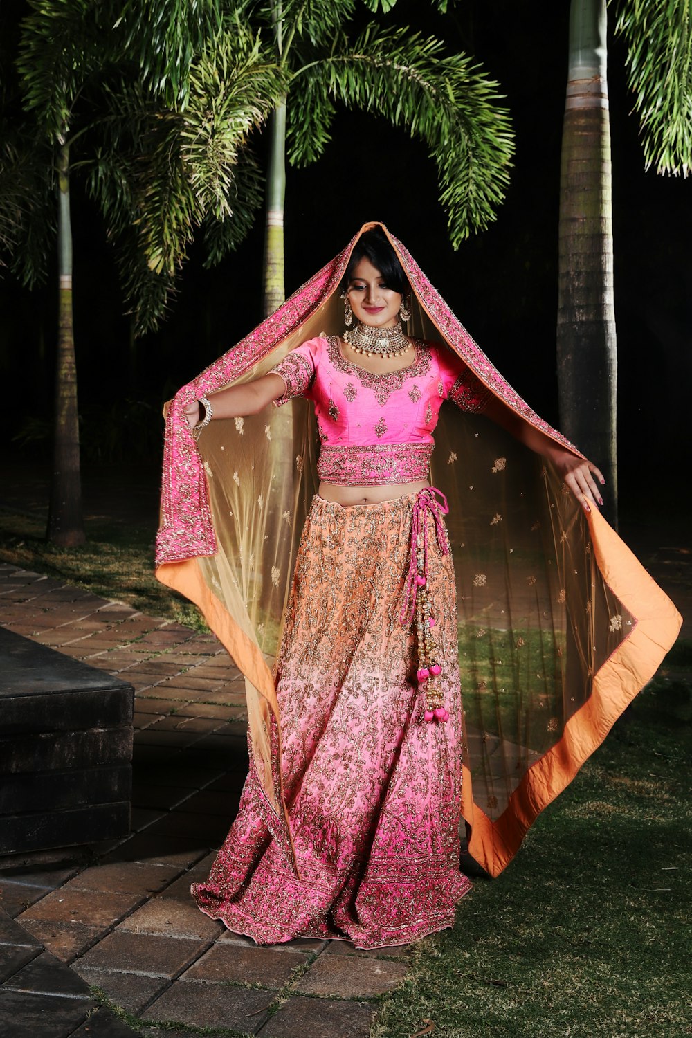 Mulher em sari roxo e marrom em pé na ponte de madeira marrom