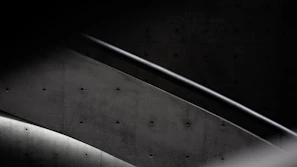 Detail shot of an industrial-style iron handrail mounted on a concrete staircase.