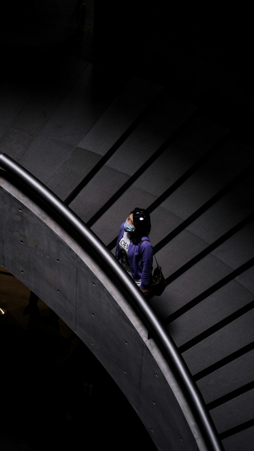 woman in purple jacket standing on stairs