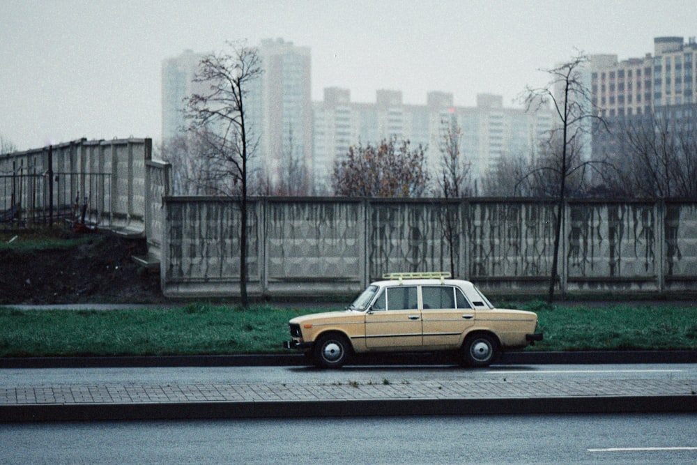 yellow sedan parked on sidewalk near city buildings during daytime