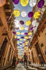 pink and white umbrella hanging on the street