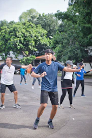 man in blue crew neck t-shirt and black shorts running on gray concrete road during