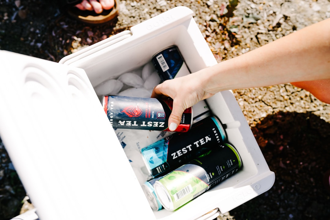  person holding green and red can cooler