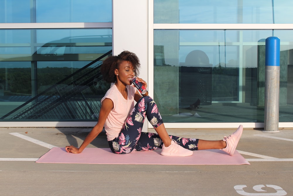 woman in white tank top and pink floral skirt sitting on floor