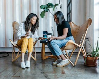 An indoor moment of a coach and client sharing a thoughtful conversation over a warm cup of tea.