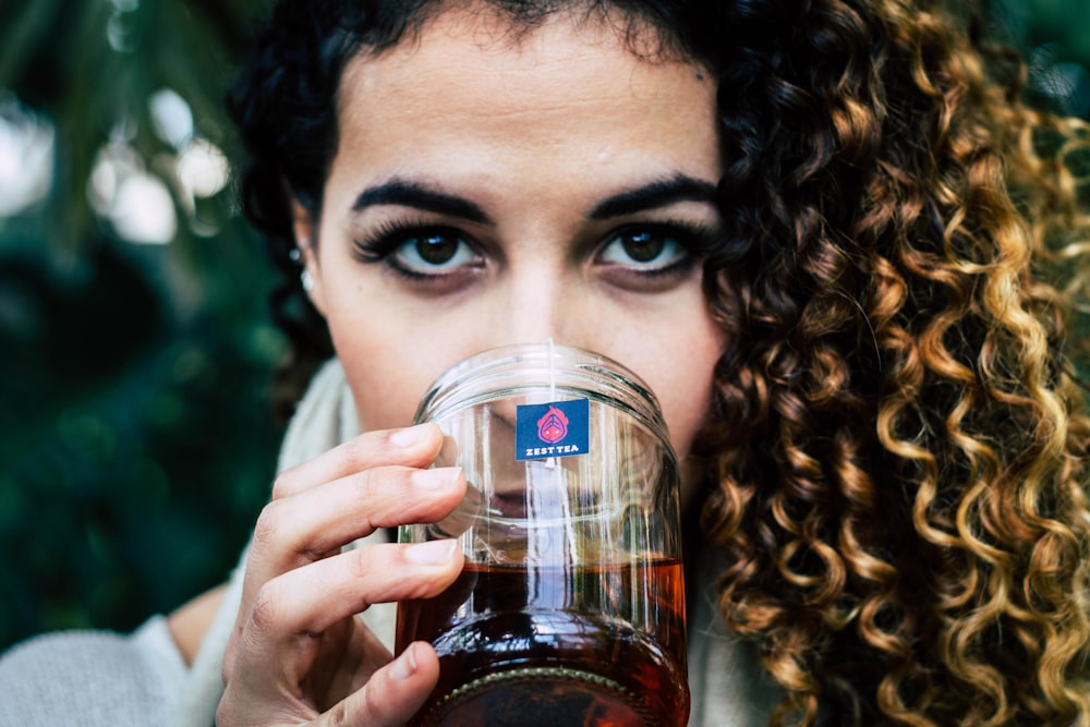 woman holding clear plastic cup