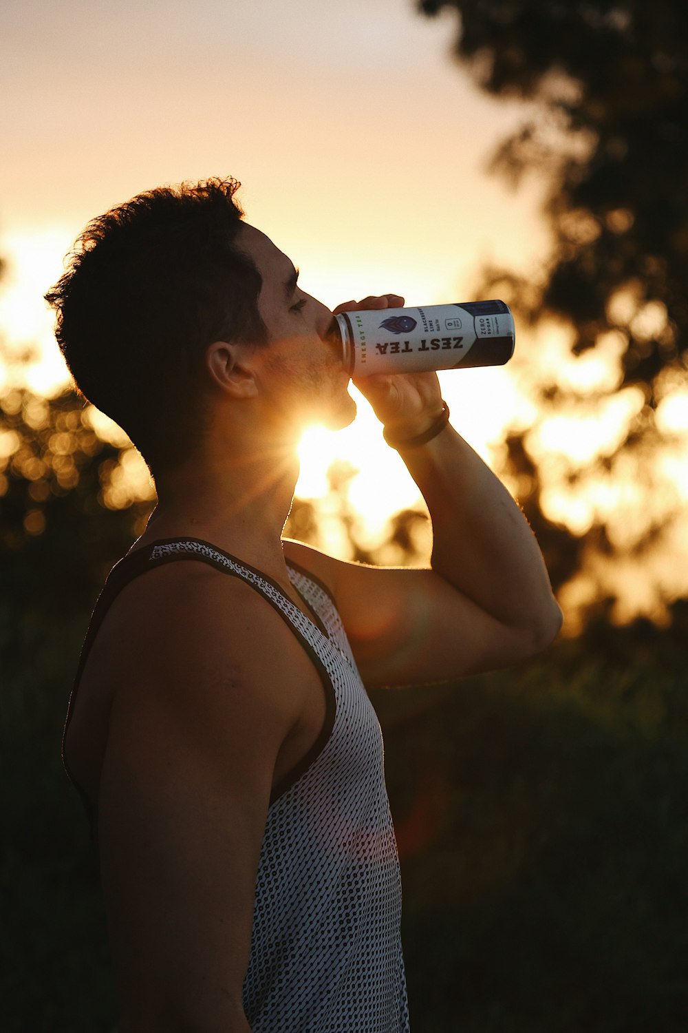 woman in black tank top drinking from bottle