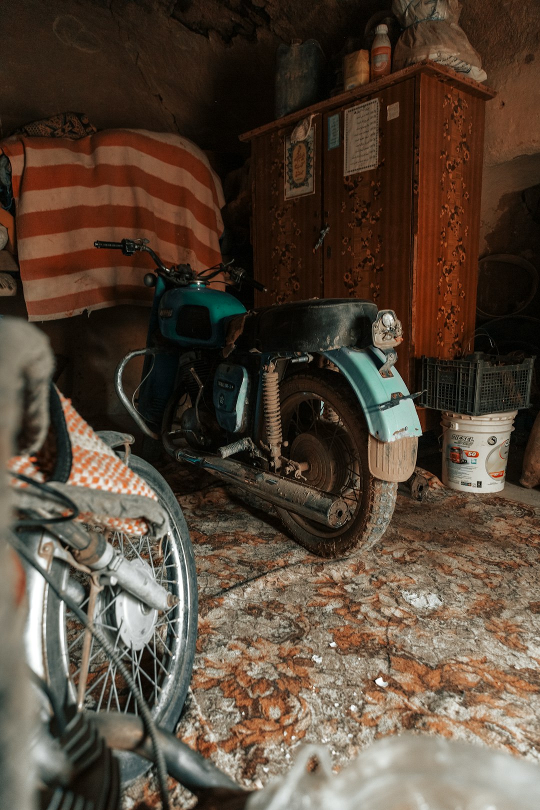 green and black motorcycle parked beside brown wooden wall