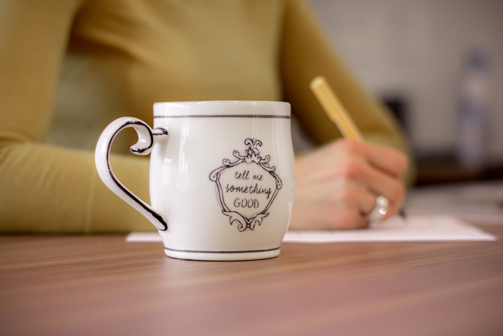 white ceramic mug on brown wooden table