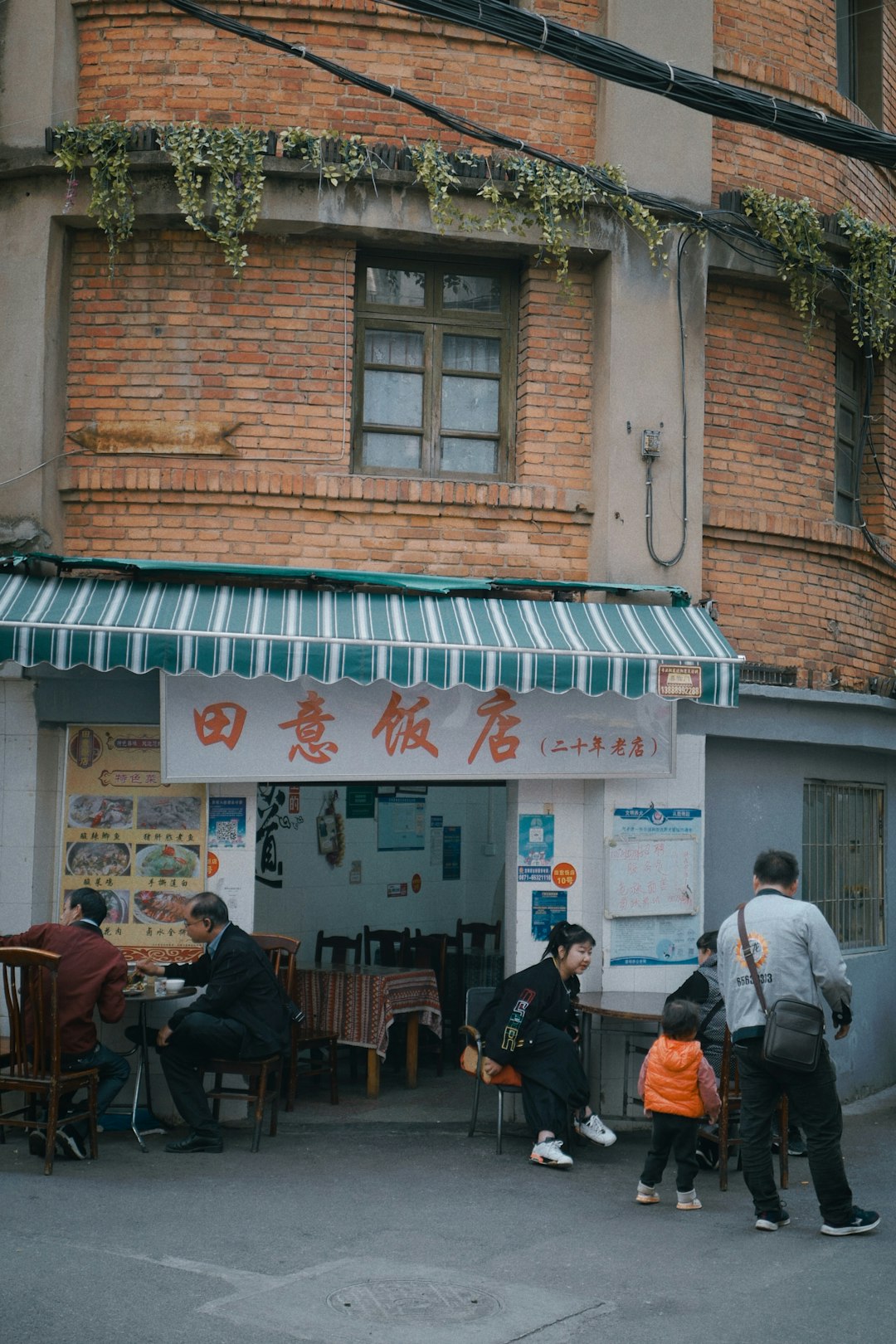 people sitting on chair near brown brick building during daytime