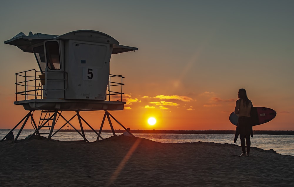 white lifeguard house on beach during sunset