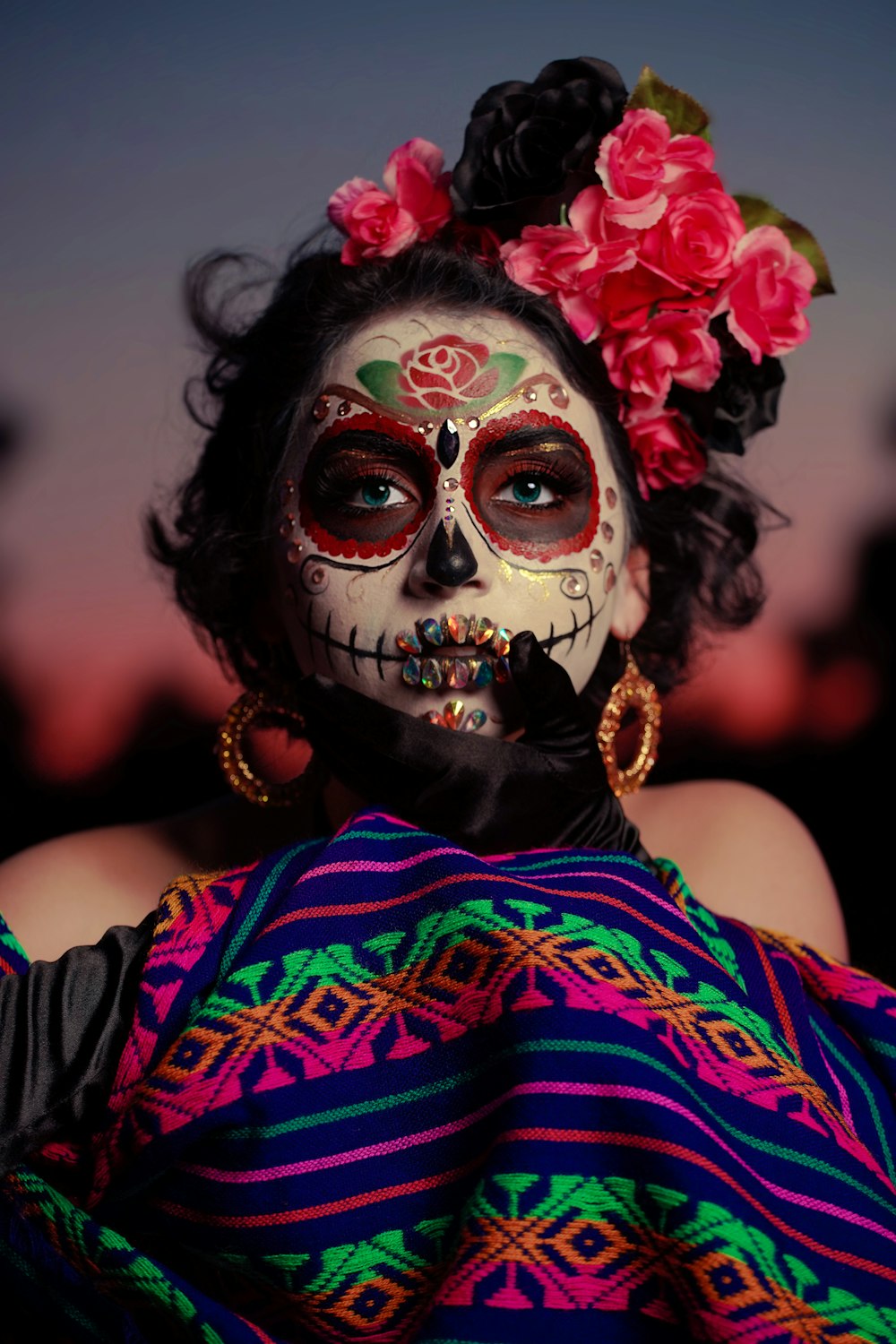 Frau in rot-blauem Blumenkleid mit weißer Maske