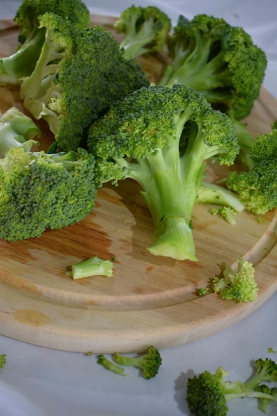 green broccoli on brown wooden round plate