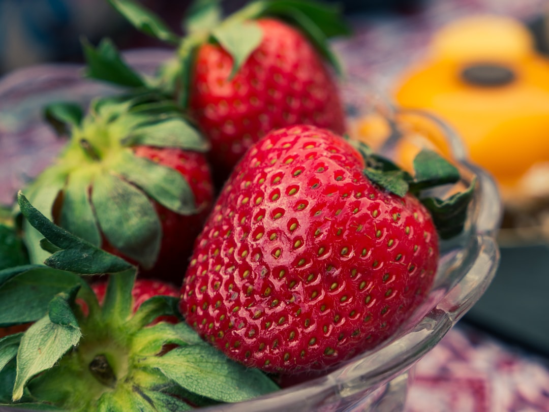 red strawberries on clear glass bowl