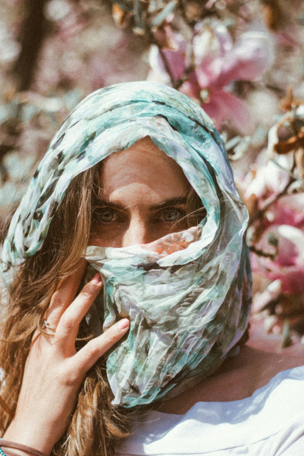 woman covering her face with green and white textile