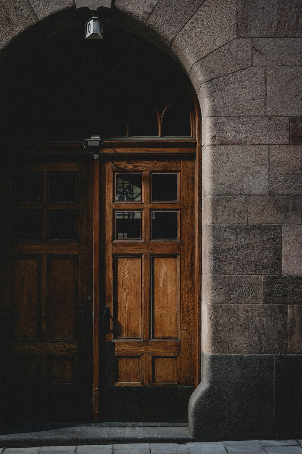 porta de madeira marrom na parede de concreto cinza