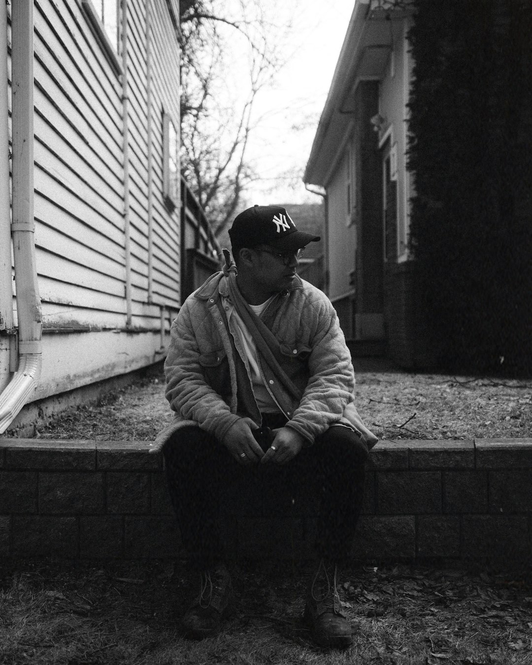 man in jacket sitting on concrete bench