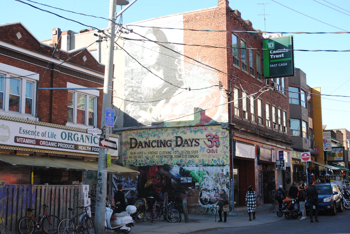 People walking past colourful independent shops in Kensington Market, Toronto
