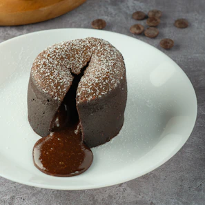 Close-up of a rich chocolate lava cake with molten center and a dusting of powdered sugar.