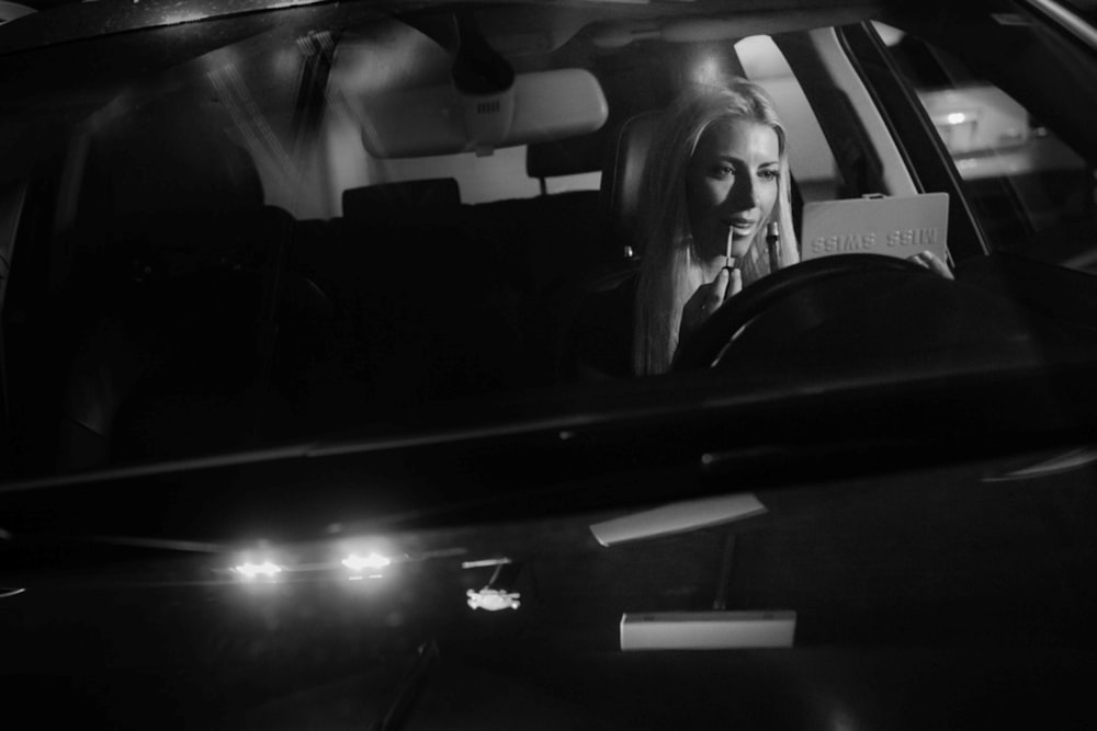 grayscale photo of woman in car