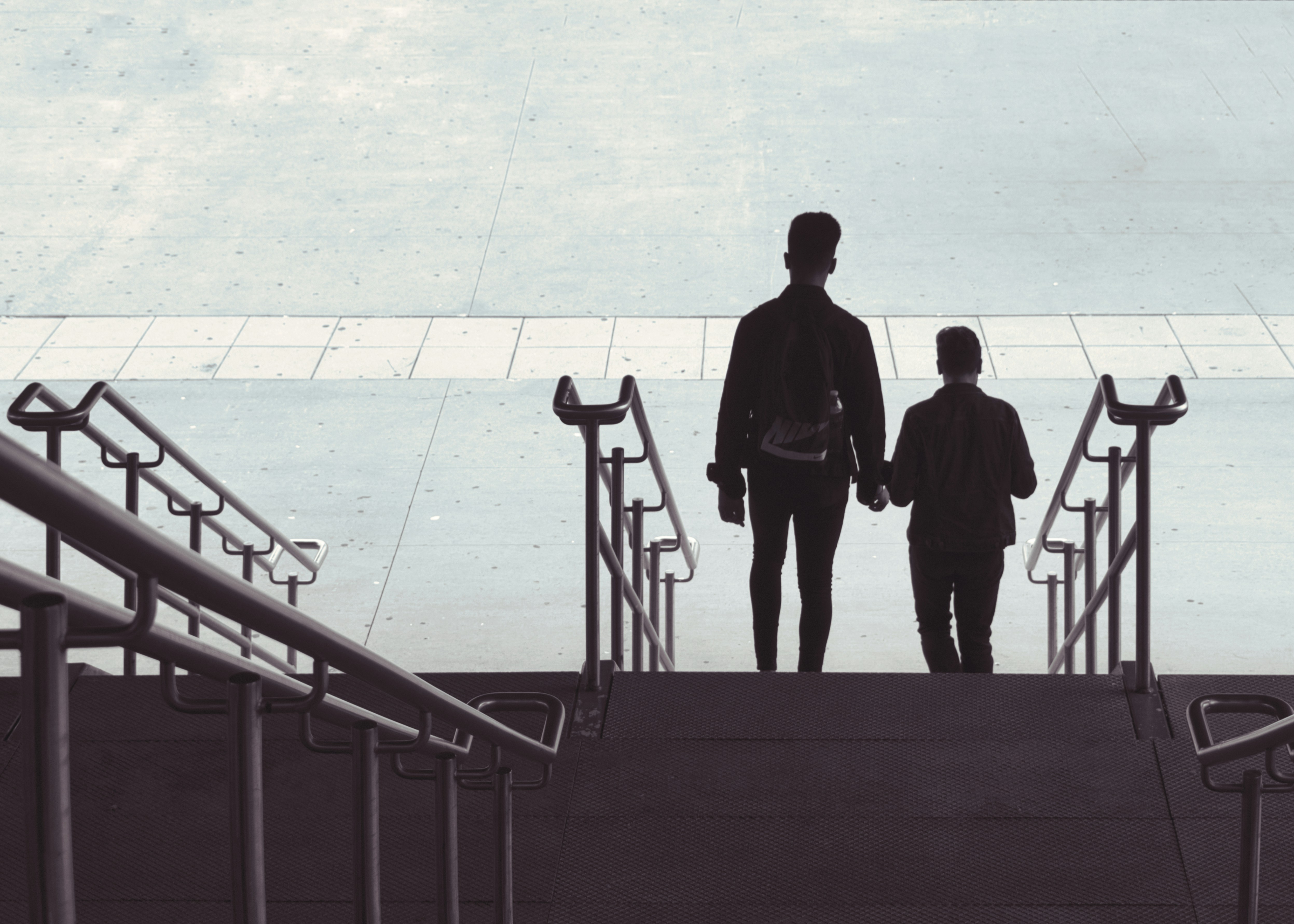 silhouette of 2 men standing on the stairs