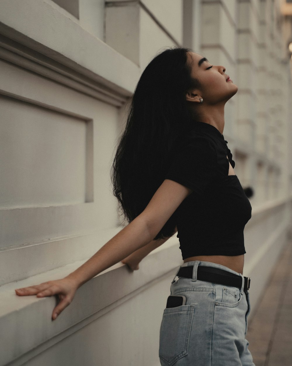 donna in t-shirt nera e jeans blu denim