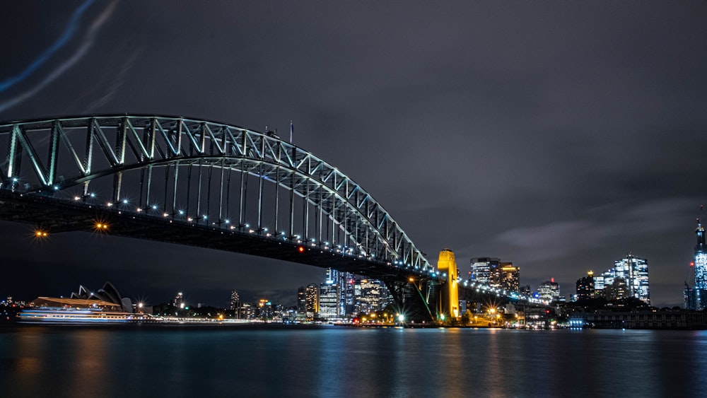 gray steel bridge over body of water during night time