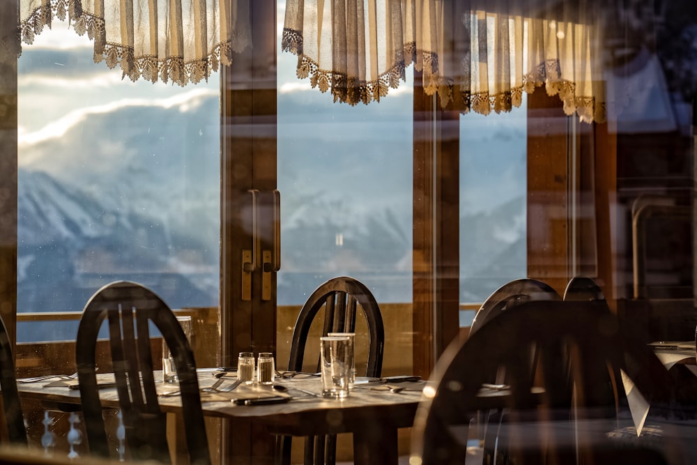 dining table and chairs near glass window