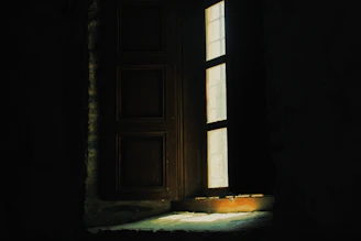 A dimly lit room with eerie shadows cast by flickering candles, evoking a classic horror game atmosphere.