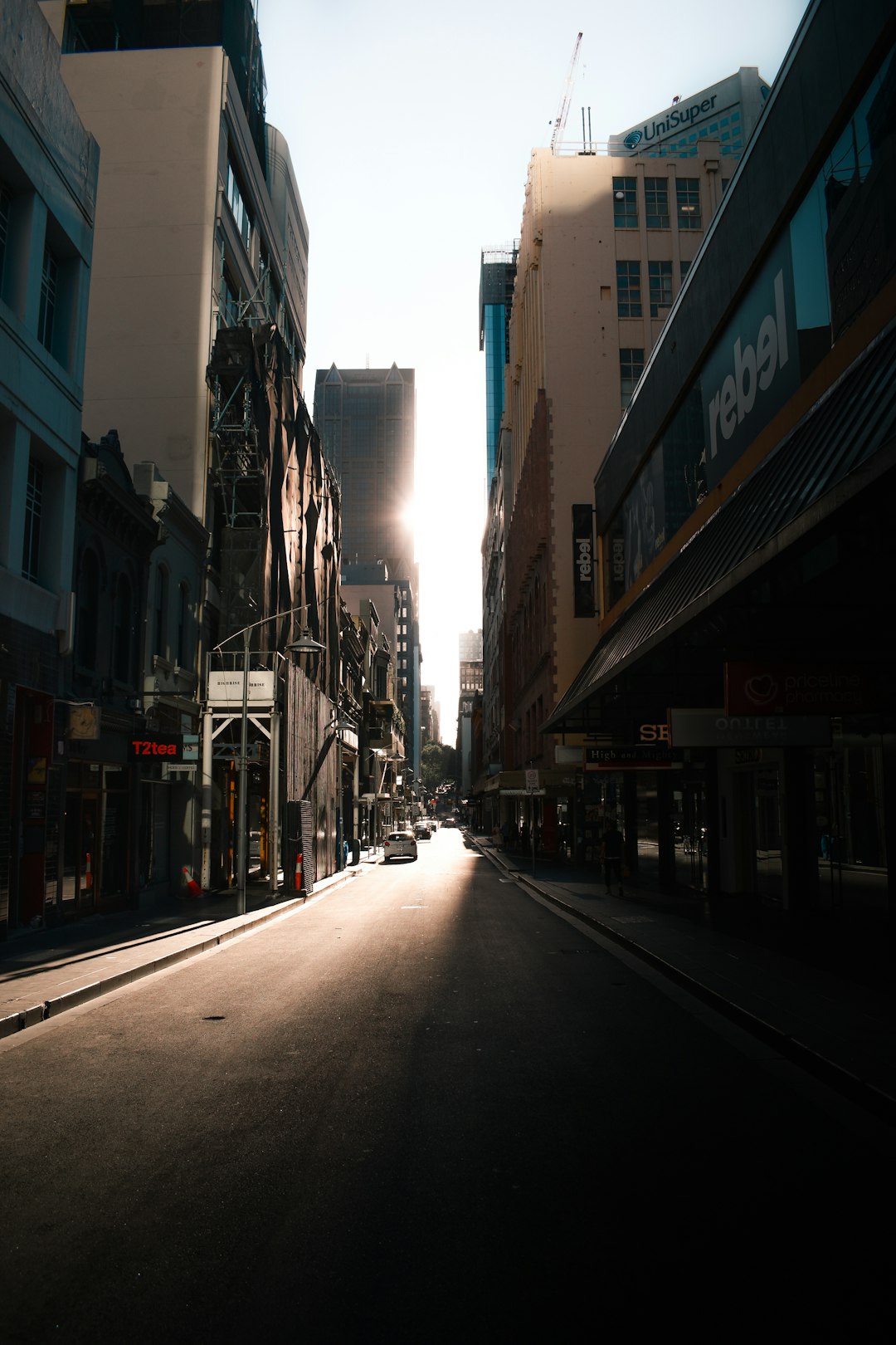 cars parked on side of the road in between buildings during daytime