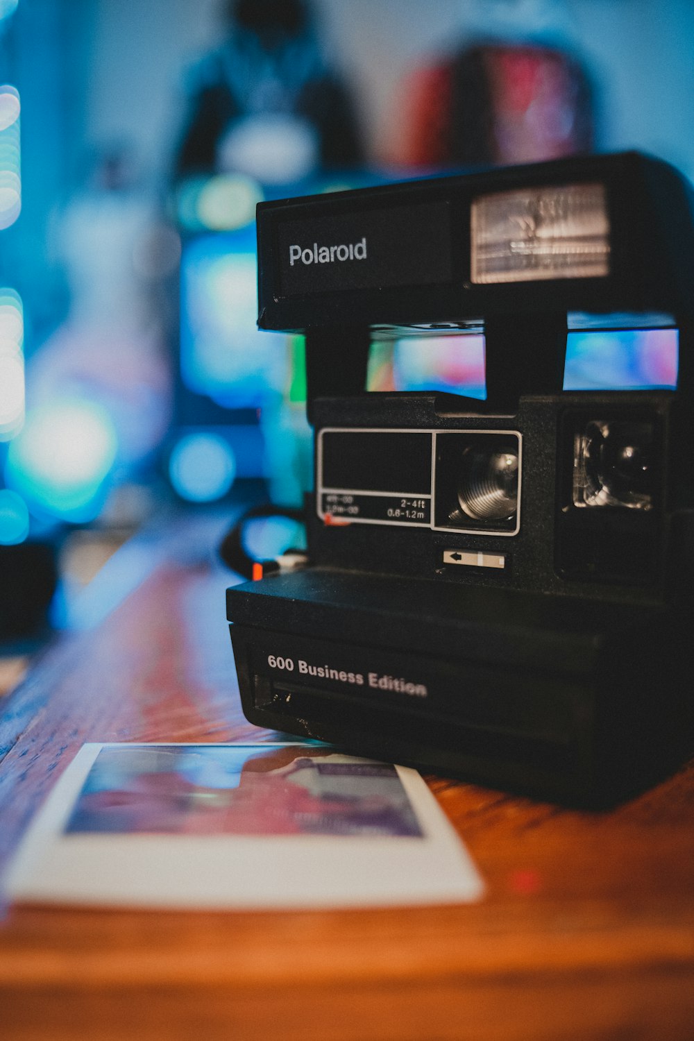 black polaroid camera on brown wooden table