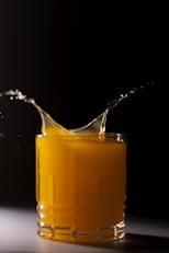 orange juice in clear drinking glass