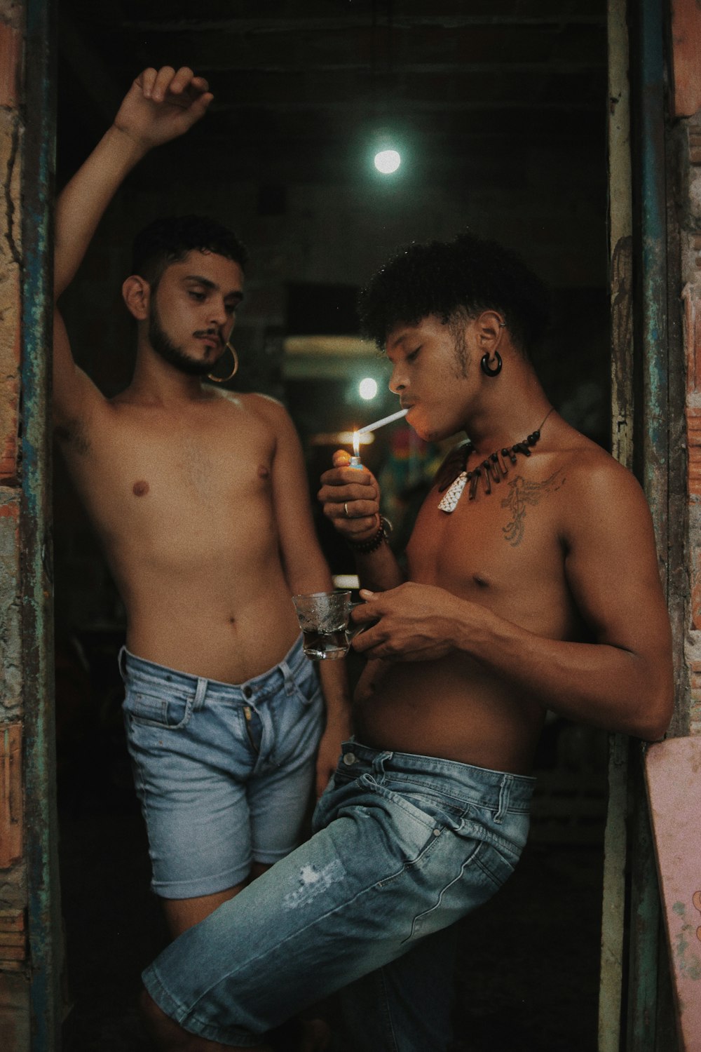 topless man and woman in blue denim jeans holding lighted candle