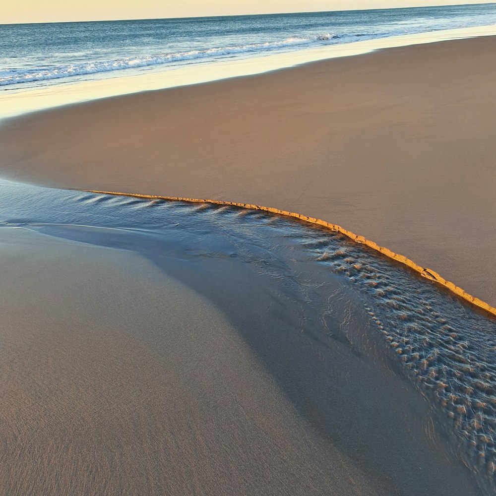 brown sand and body of water