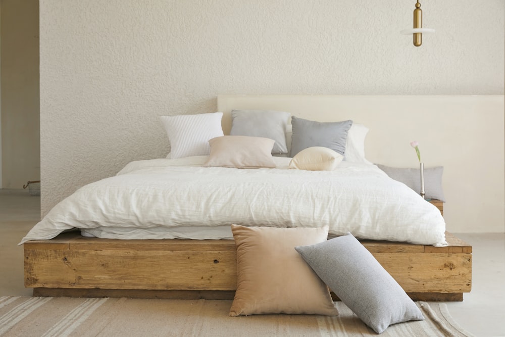 travesseiro de cama branco na estrutura da cama de madeira marrom