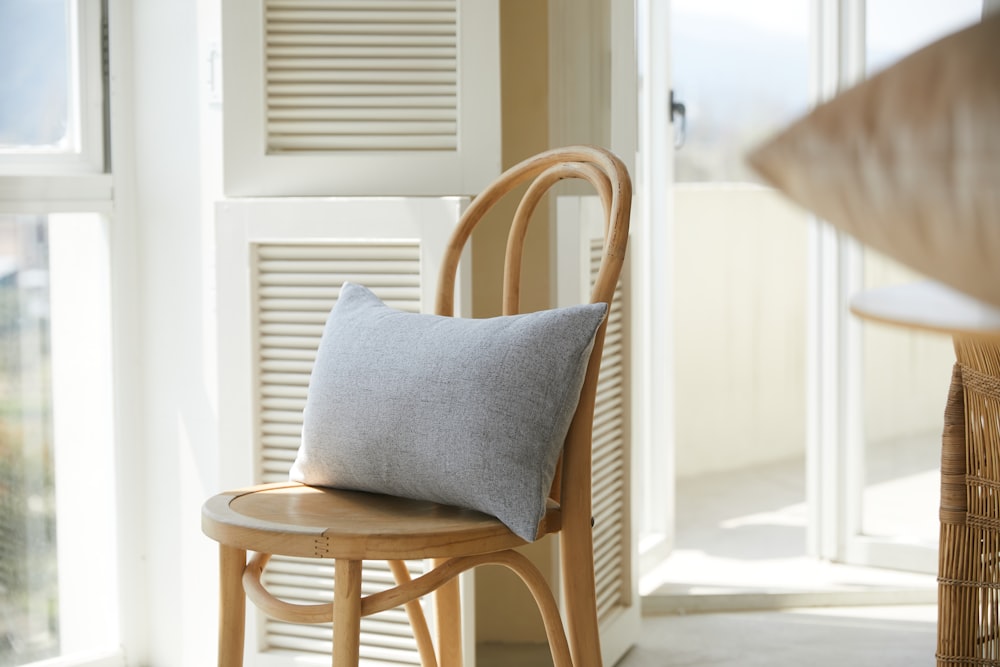 brown wooden chair with gray cushion