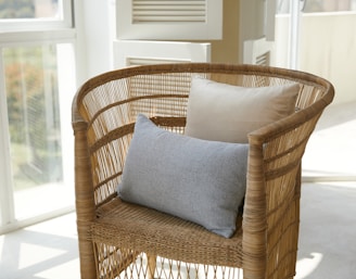 brown wicker armchair with two cushions