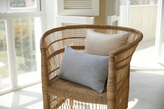 brown wicker armchair with two cushions