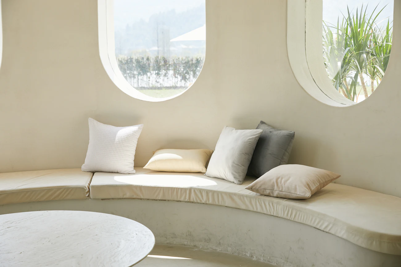 A pale sofa beside a small round table in a light, unhurried room