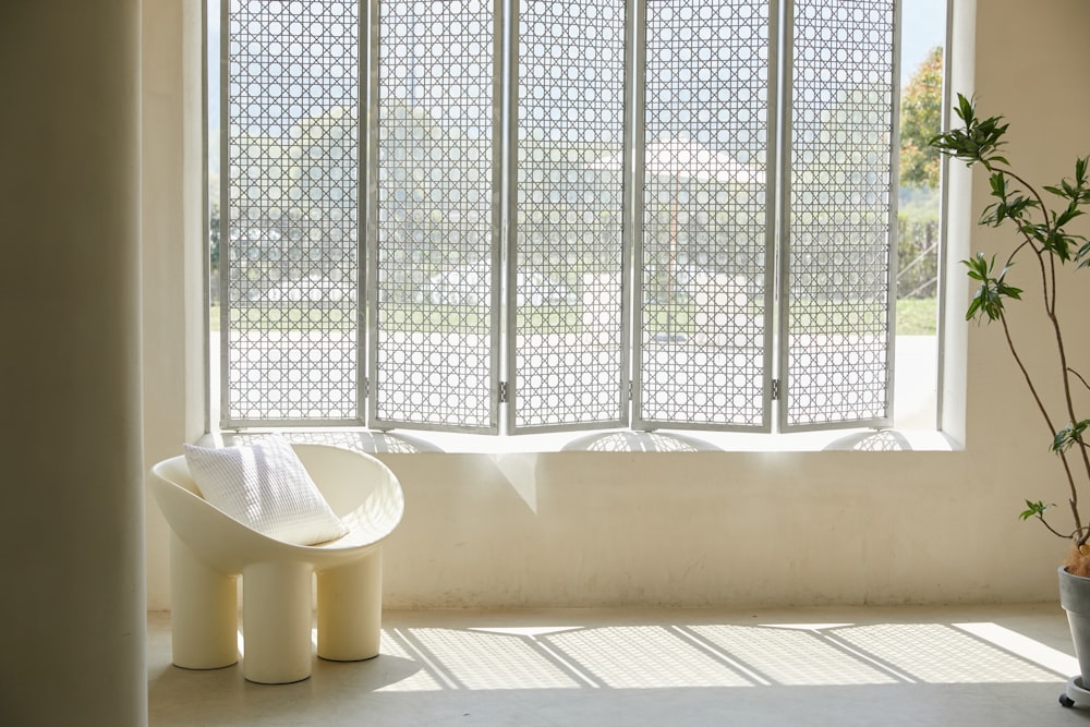 white plastic trash bin beside white curtain