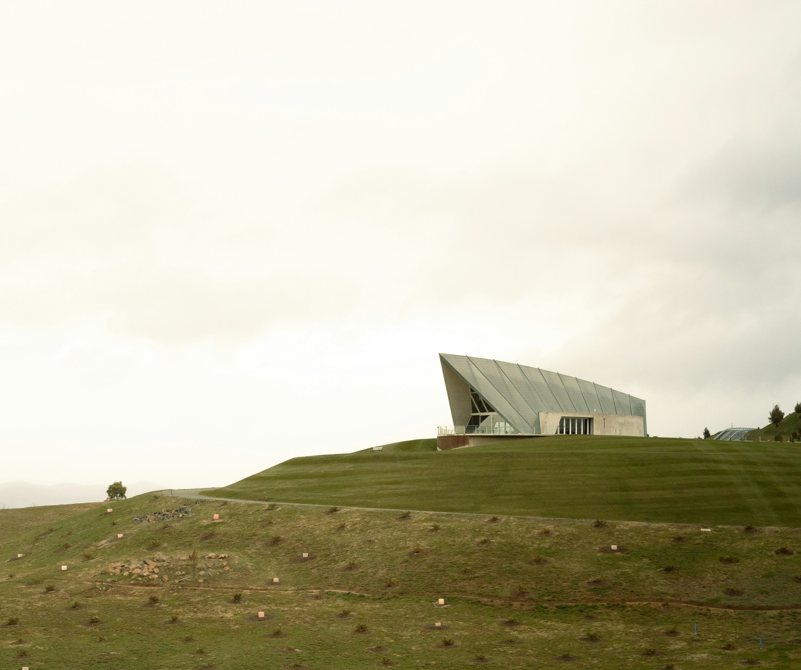 white building on green grass field under white sky during daytime