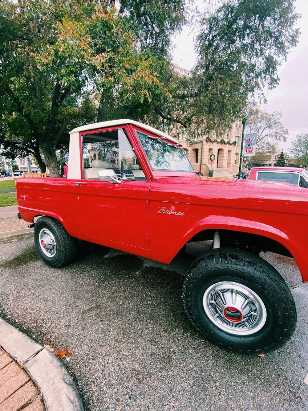 red single cab pickup truck parked near green trees during daytime