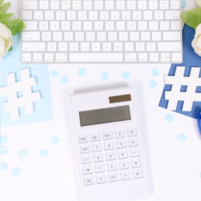 white and black calculator on white and blue textile