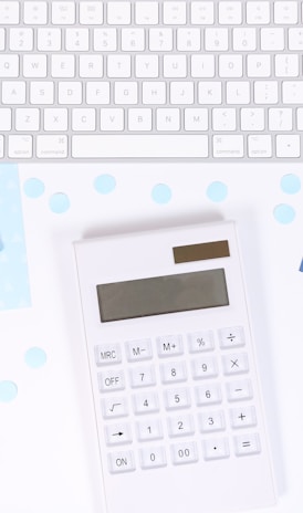 white and black calculator on white and blue textile